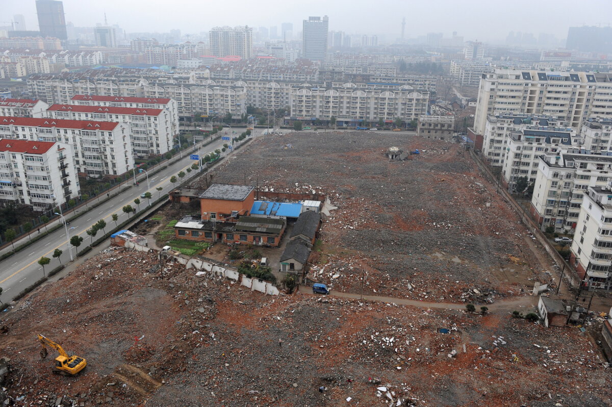 Công nhân Trung Quốc ủi một mảnh đất để dọn chỗ cho việc xây dựng một chung cư cao tầng mới ở Hợp Phì, tỉnh An Huy, phía đông Trung Quốc, ngày 06/03/2010. (Ảnh: STR/AFP qua Getty Images)