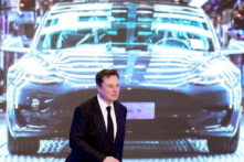 Ông Elon Musk, Tổng giám đốc Tesla, đứng cạnh một màn hình đang chiếu hình ảnh một chiếc Tesla Model 3 trong buổi lễ khai trương Model Y sản xuất tại Trung Quốc, ở Thượng Hải ngày 07/01/2020. (Ảnh: Aly Song/Reuters)